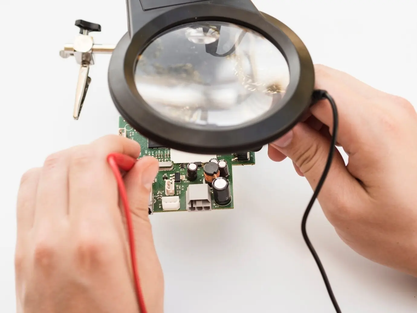 Ein Mann benutzt ein Multimeter, um eine Platine zu überprüfen.